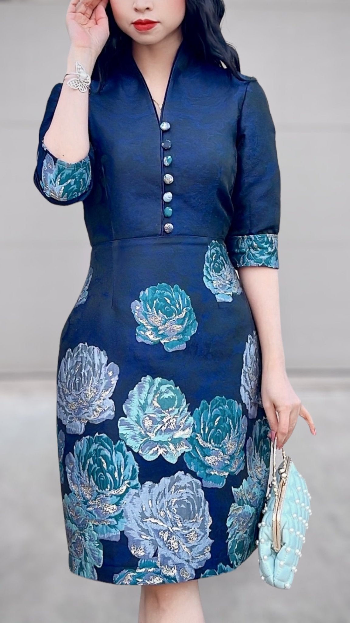 •	“Blue floral brocade dress with mandarin collar”
	•	“Elegant women’s formal dress with 3/4 sleeves and buttons”
	•	“Asian-inspired blue dress with silver and teal floral pattern”